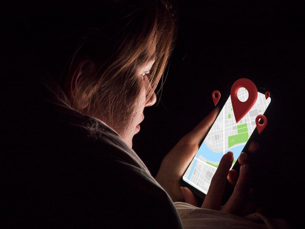 kobieta używająca aplikacji map na telefonie w ciemności