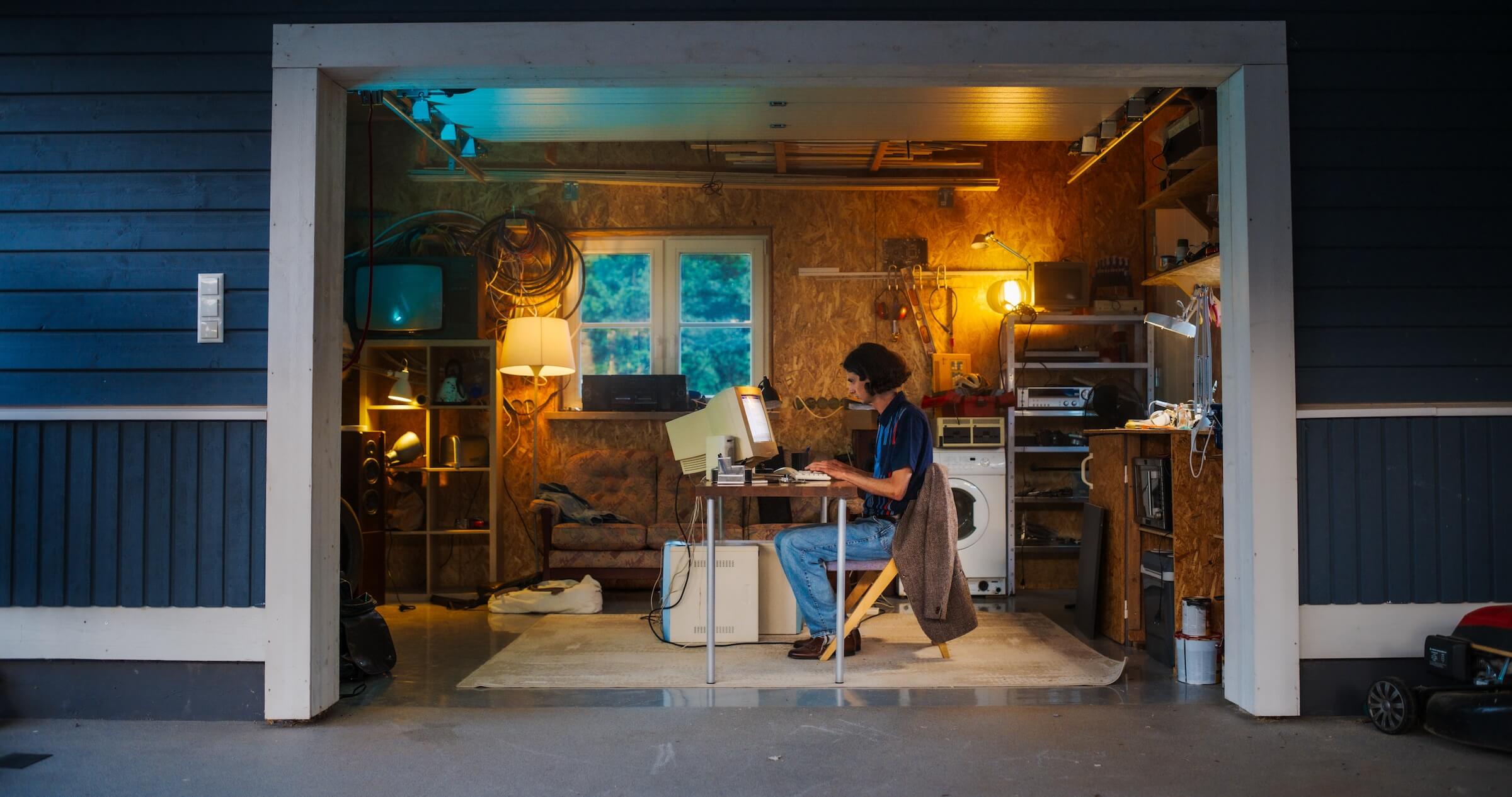 Kaukaski mężczyzna inżynier oprogramowania programujący na starym komputerze stacjonarnym w garażu retro