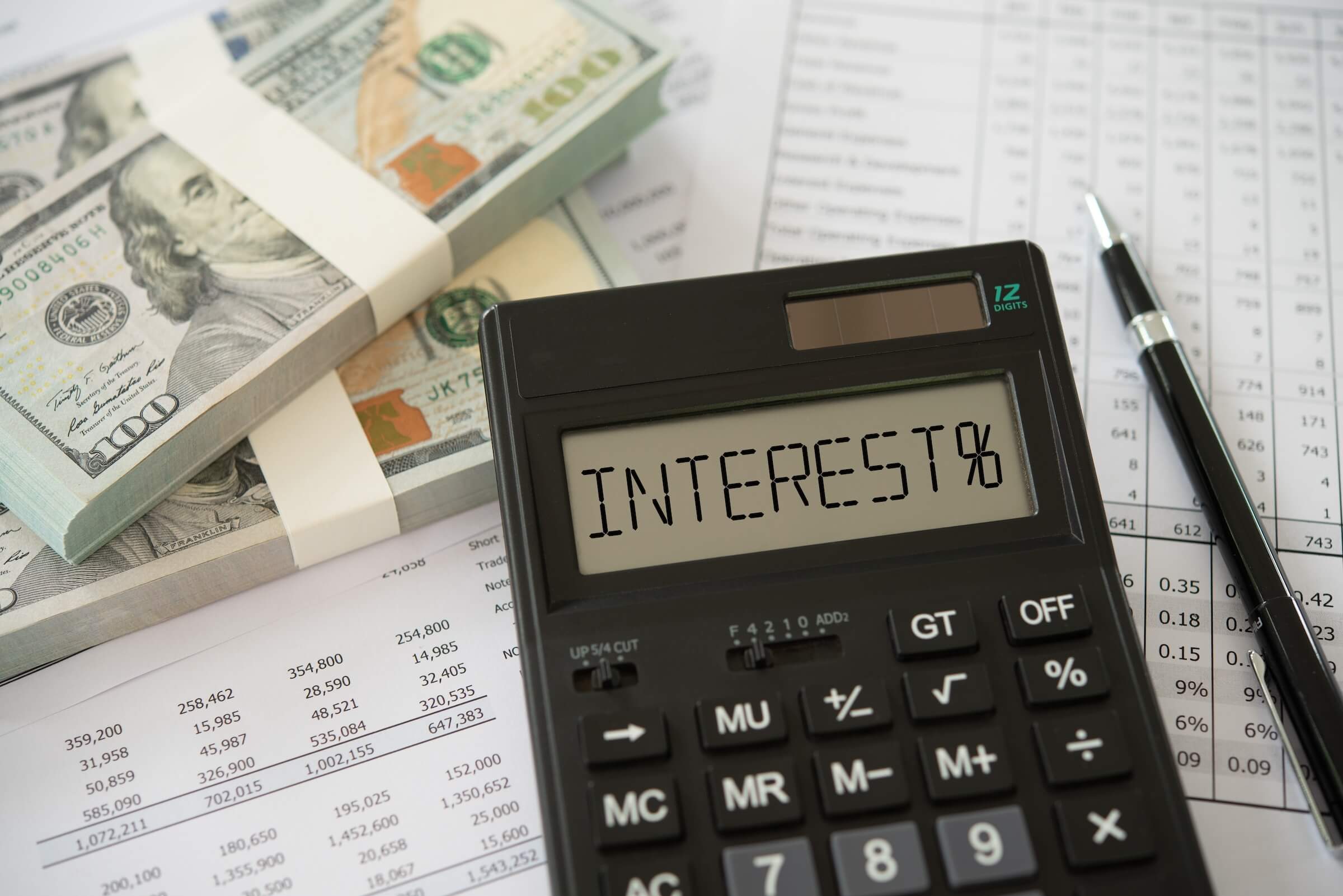 Koncepcja bankowości finansowej i odsetek wyrażenie "interest%" na kalkulatorze z banknotem dolarowym